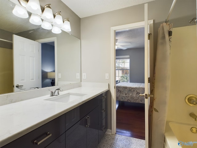 bathroom with a textured ceiling, vanity, wood-type flooring, shower / bathtub combination with curtain, and ceiling fan