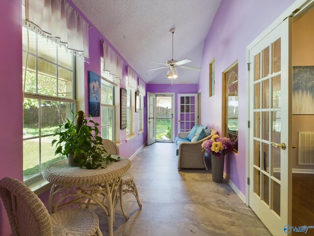 sunroom with lofted ceiling, ceiling fan, and french doors