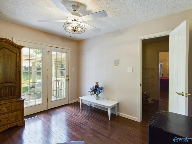 entryway featuring dark wood-type flooring, ceiling fan, and a textured ceiling