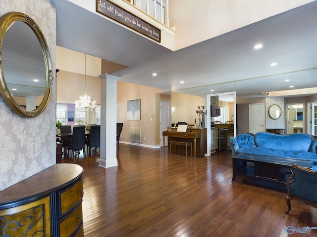 living room featuring decorative columns, recessed lighting, wood finished floors, baseboards, and wallpapered walls