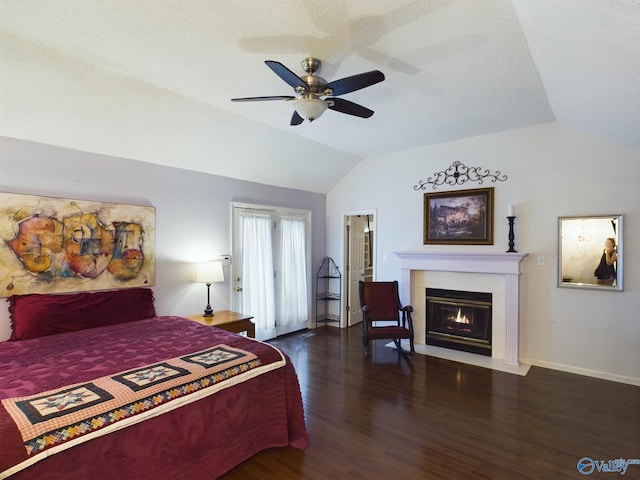 bedroom with lofted ceiling, a fireplace with flush hearth, a textured ceiling, wood finished floors, and baseboards