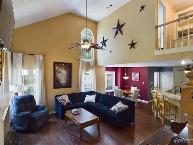 living room with dark wood-type flooring, ceiling fan, and high vaulted ceiling