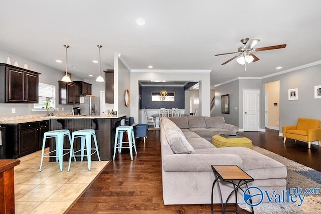 living room with crown molding, ceiling fan, and dark hardwood / wood-style floors