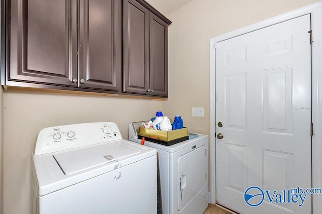 washroom with cabinets and washing machine and clothes dryer