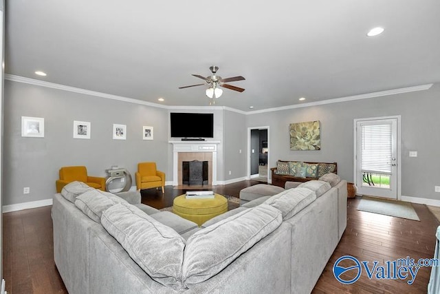 living room featuring a fireplace, ornamental molding, dark hardwood / wood-style floors, and ceiling fan