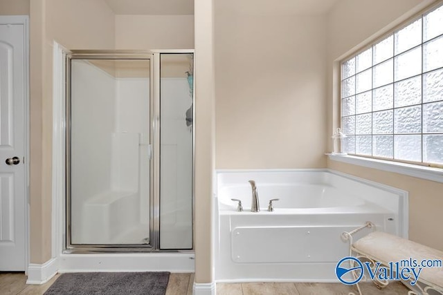 bathroom featuring a wealth of natural light and shower with separate bathtub