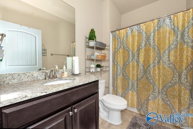 bathroom featuring tile patterned flooring, vanity, and toilet