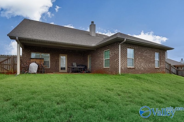 rear view of house featuring a yard