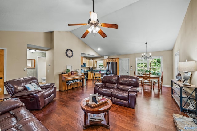 living room featuring ceiling fan with notable chandelier, dark wood-type flooring, and high vaulted ceiling