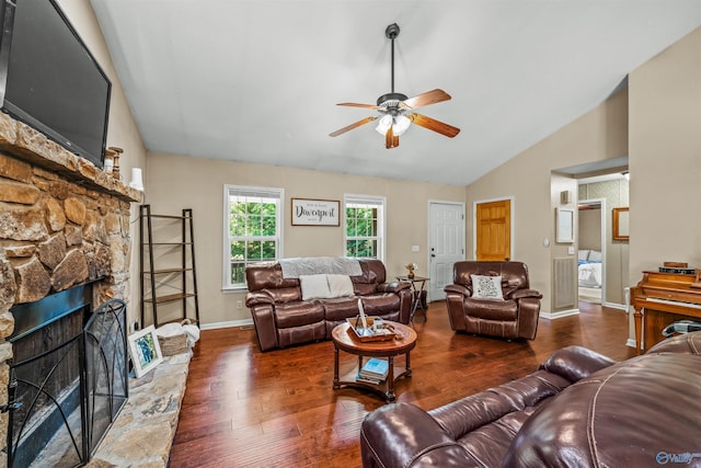 living room with ceiling fan, vaulted ceiling, a fireplace, and dark wood-type flooring