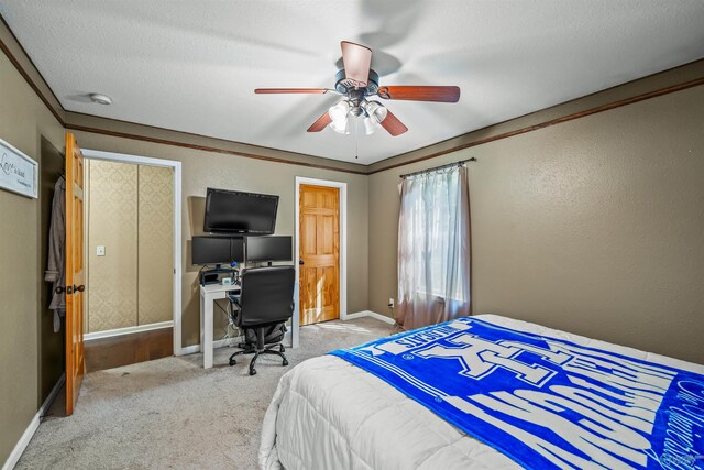 bedroom featuring ceiling fan, a textured ceiling, ornamental molding, and light carpet