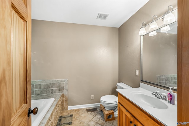 bathroom with toilet, tile patterned floors, vanity, and tiled bath