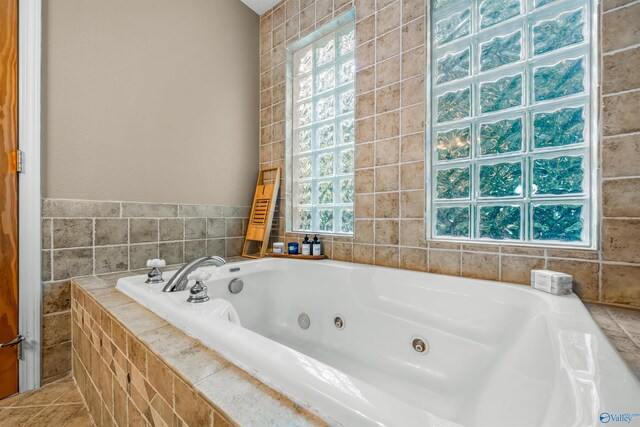 bathroom featuring tile patterned flooring and tiled bath