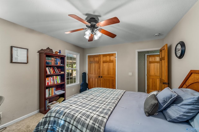 carpeted bedroom featuring ceiling fan and a closet