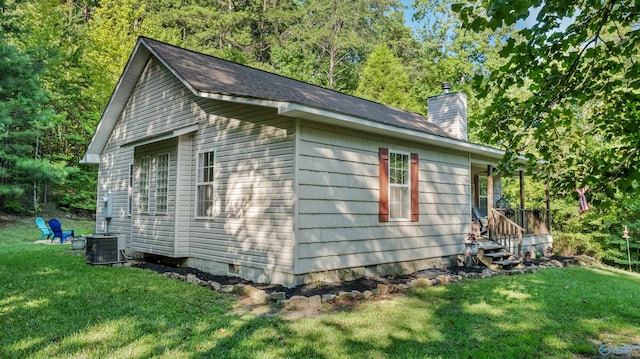 view of property exterior with central AC and a lawn