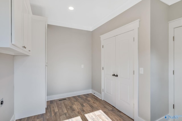 interior space with dark hardwood / wood-style floors and crown molding