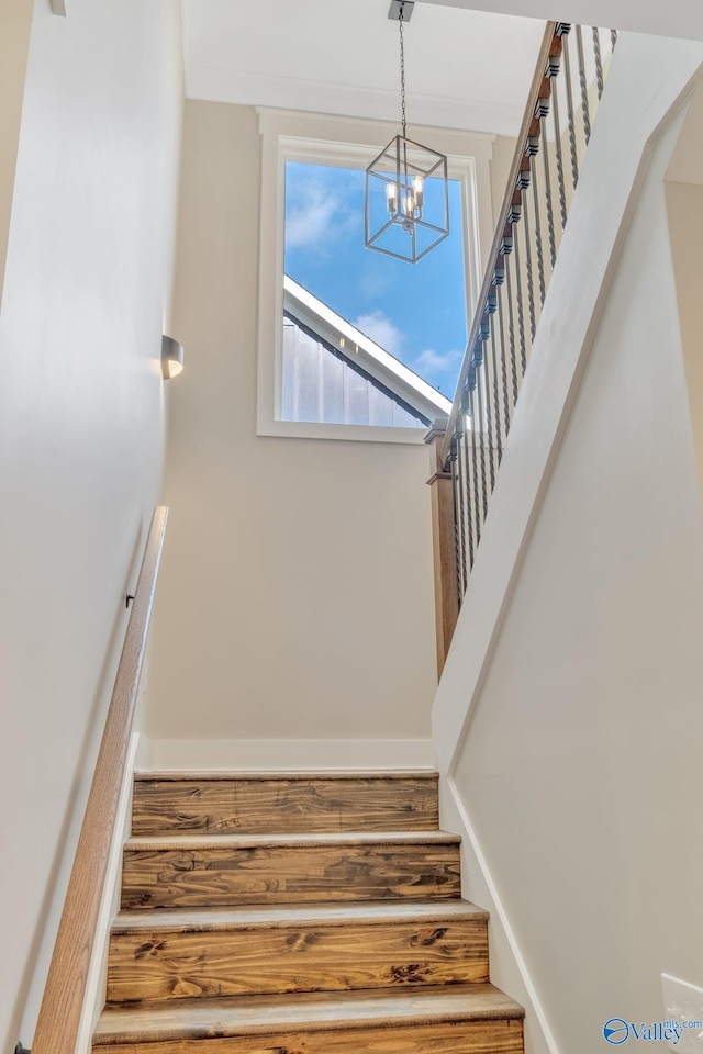 stairway with a notable chandelier and hardwood / wood-style flooring