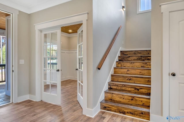 staircase with hardwood / wood-style floors, a healthy amount of sunlight, and french doors