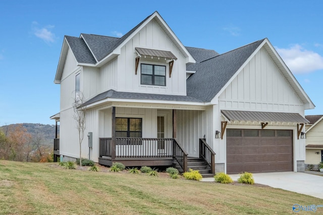 modern inspired farmhouse featuring covered porch, a front yard, and a garage