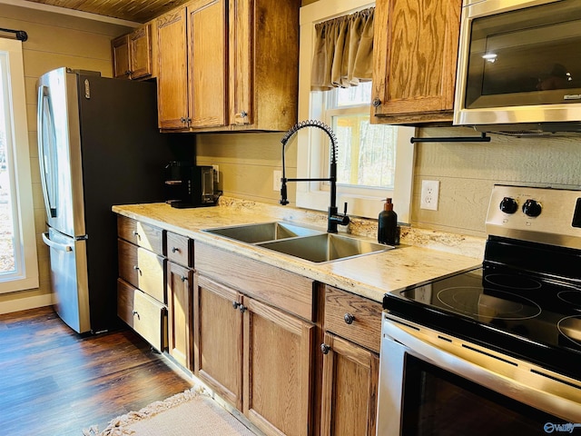 kitchen featuring a wealth of natural light, sink, appliances with stainless steel finishes, and dark wood-type flooring