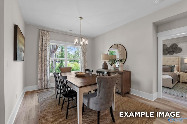 dining room featuring a notable chandelier and light wood-type flooring