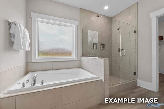 bathroom featuring hardwood / wood-style flooring and separate shower and tub