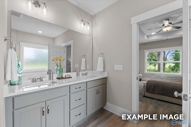 bathroom with double sink vanity, wood-type flooring, and ceiling fan