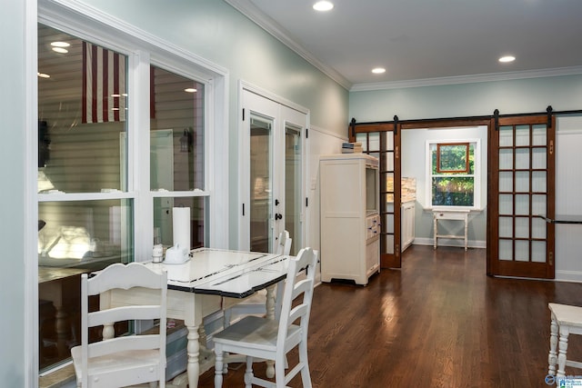 dining space with a barn door, crown molding, french doors, and dark hardwood / wood-style flooring