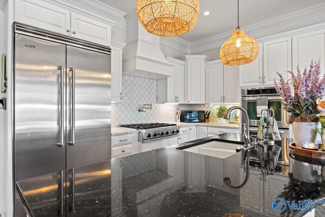 3127 Haddonstone Dr SE, Owens Cross Roads, AL 35763 - kitchen featuring stainless steel appliances, a sink, white cabinets, premium range hood, and dark stone countertops