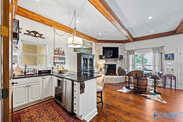 3127 Haddonstone Dr SE, Owens Cross Roads, AL 35763 - kitchen featuring beam ceiling, a sink, dark countertops, open floor plan, and a fireplace