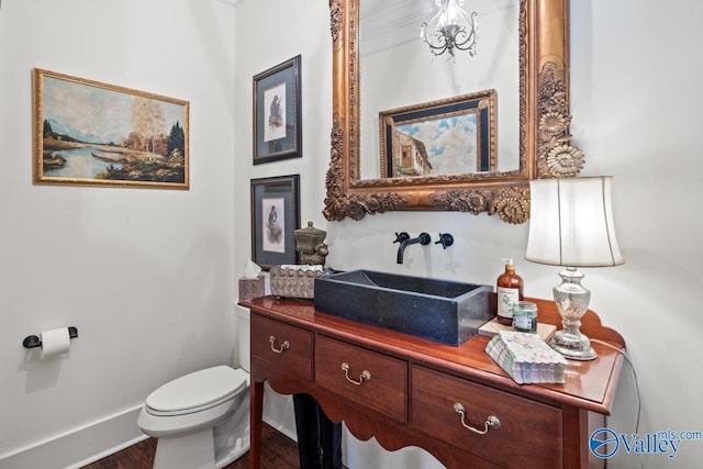 3127 Haddonstone Dr SE, Owens Cross Roads, AL 35763 - half bathroom featuring toilet, vanity, wood finished floors, and baseboards