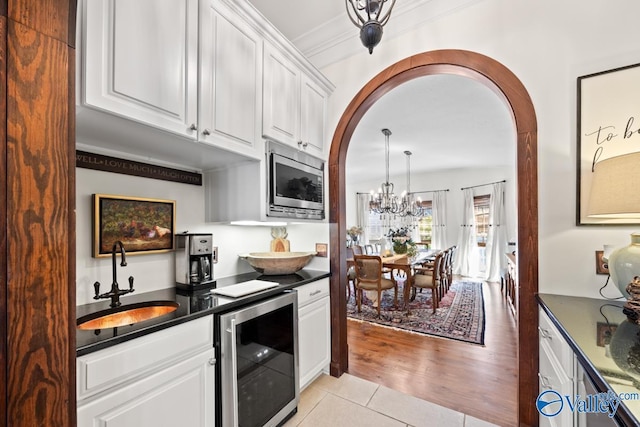 3127 Haddonstone Dr SE, Owens Cross Roads, AL 35763 - kitchen featuring wine cooler, a sink, arched walkways, and stainless steel microwave