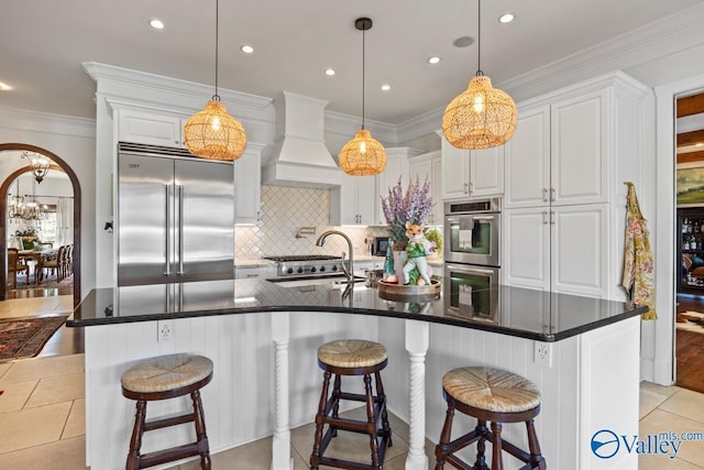 3127 Haddonstone Dr SE, Owens Cross Roads, AL 35763 - kitchen featuring appliances with stainless steel finishes, a sink, white cabinetry, decorative backsplash, and a kitchen bar