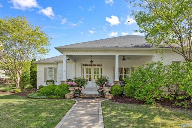 view of front of home featuring covered porch, a front yard, brick siding, a ceiling fan, and a shingled roof