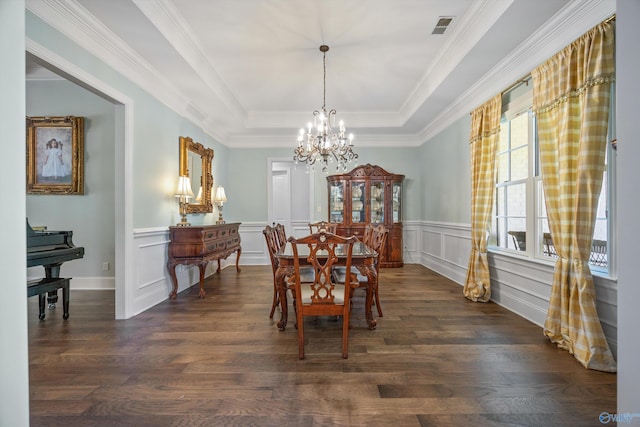 dining space featuring visible vents, crown molding, a raised ceiling, dark wood-style floors, and a chandelier