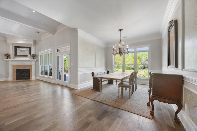 dining room with ornamental molding, a fireplace, wood finished floors, and a chandelier
