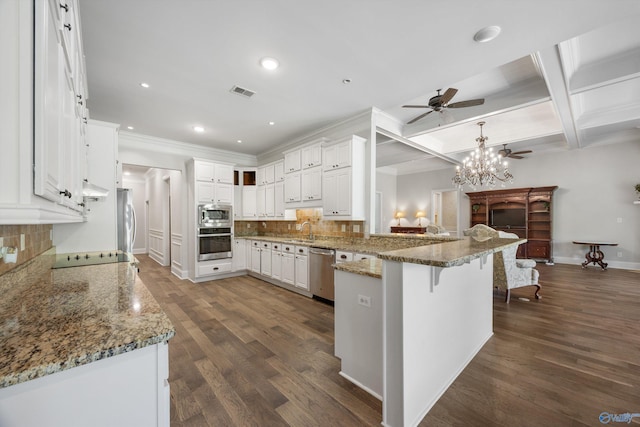 kitchen featuring ceiling fan with notable chandelier, stainless steel appliances, a peninsula, backsplash, and visible vents