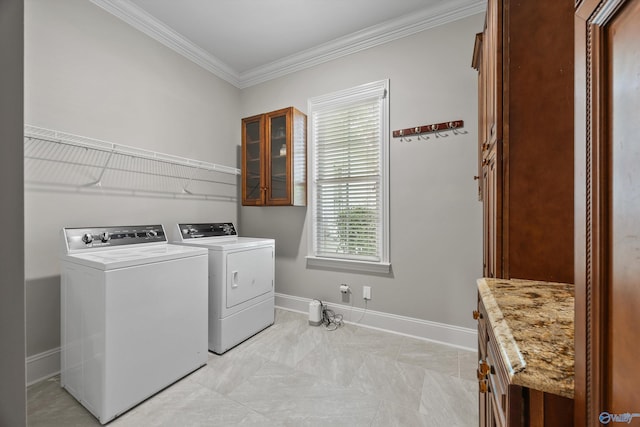 washroom featuring baseboards, ornamental molding, cabinet space, and washer and dryer