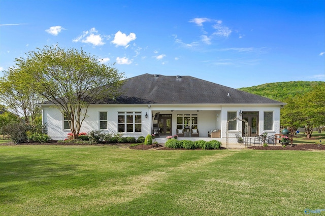 back of house featuring a lawn, a patio area, and french doors