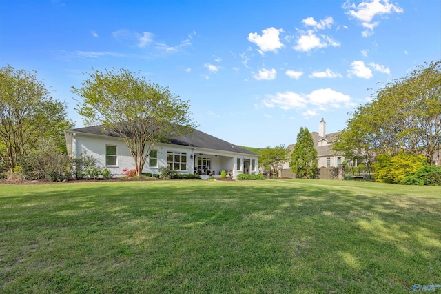 rear view of property featuring a lawn