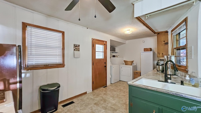 325 Crestview St, Athens, AL 35611 - kitchen with washer and dryer, freestanding refrigerator, green cabinets, ceiling fan, and light countertops
