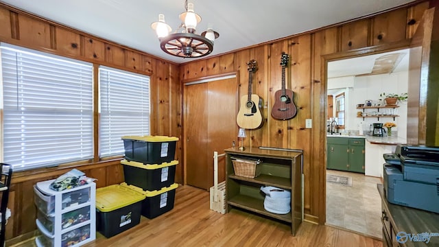 325 Crestview St, Athens, AL 35611 - misc room with a chandelier, wood walls, plenty of natural light, and light wood-style flooring