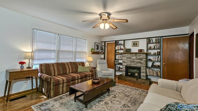 325 Crestview St, Athens, AL 35611 - living area with a ceiling fan, wood finished floors, and a stone fireplace