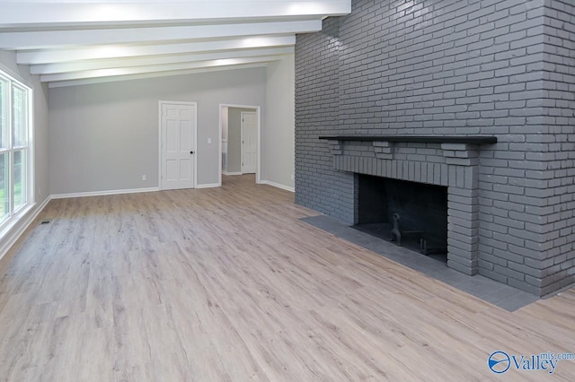 unfurnished living room with baseboards, wood finished floors, vaulted ceiling with beams, and a fireplace