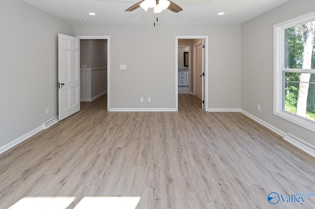unfurnished bedroom featuring visible vents, light wood-style floors, baseboards, recessed lighting, and a walk in closet