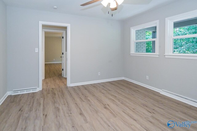 spare room featuring light hardwood / wood-style floors, a baseboard radiator, and ceiling fan