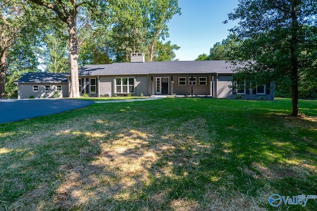 ranch-style house featuring a front yard and a chimney
