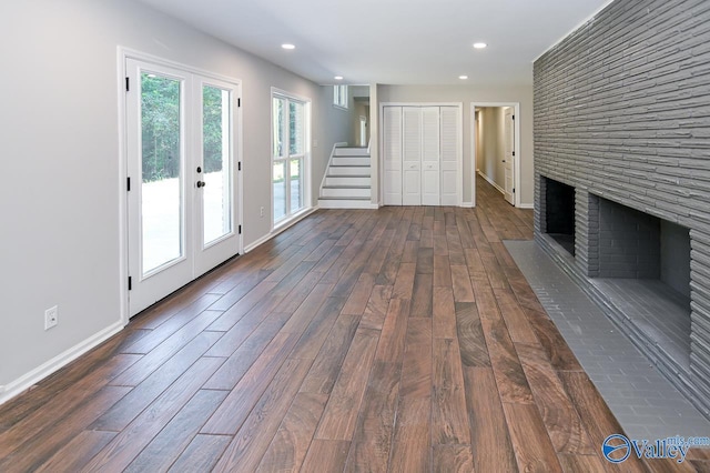 unfurnished living room with recessed lighting, dark wood-style flooring, stairway, a fireplace, and baseboards