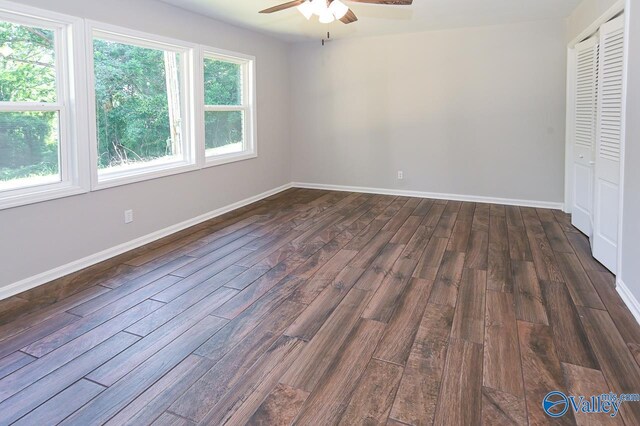 unfurnished bedroom featuring dark hardwood / wood-style floors, ceiling fan, and a closet