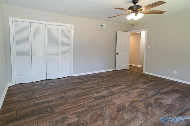 unfurnished bedroom with dark wood finished floors, a closet, ceiling fan, baseboards, and visible vents